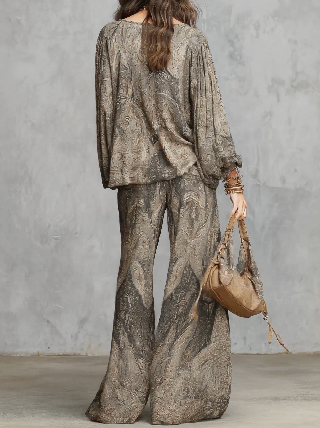 Completo composto da top a maniche a lanterna e pantaloni a gamba larga con fantasia paisley grigia.