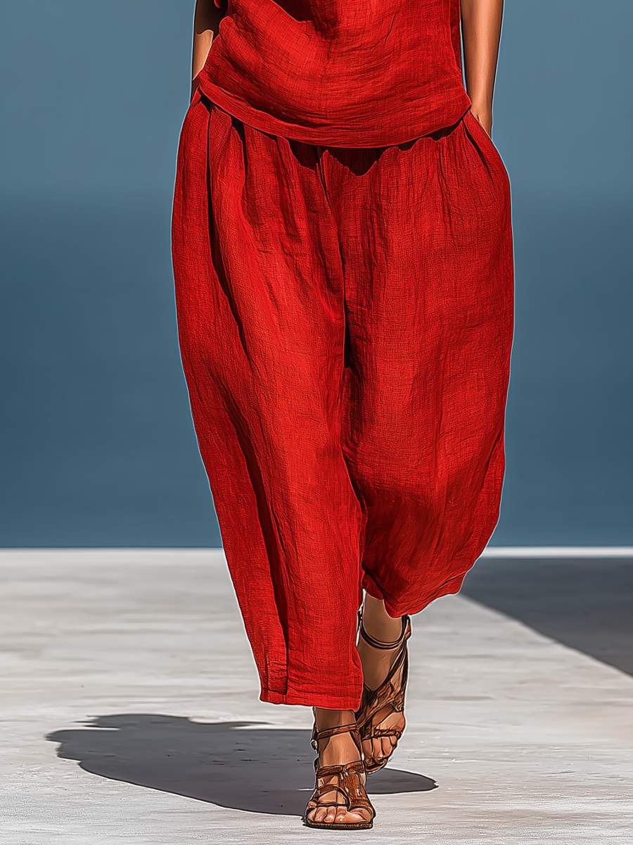 Completo due pezzi da donna in misto lino rosso: top asimmetrico monospalla e pantaloni a gamba larga con tasche.