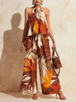 Completo composto da top all'americana e pantaloni a gamba larga con stampa di palme tropicali.