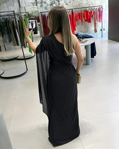 Abito da sera asimmetrico con spalla scoperta, maniche a mantella in rete, arricciature e vita intrecciata 🖤✨