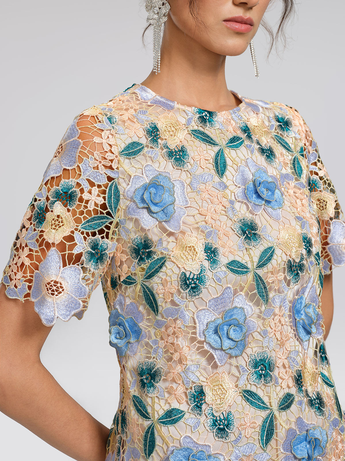 Abito in pizzo con decorazioni floreali e a foglia.