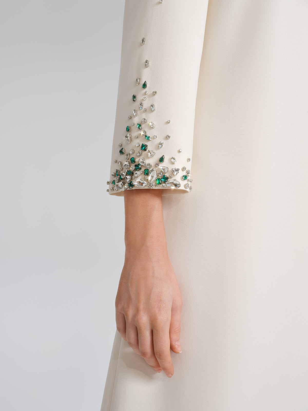 Abito a trapezio con spalline imbottite e decorazioni di perline e cristalli, realizzato a mano.
