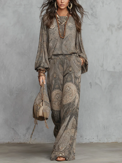 Completo composto da top a maniche a lanterna e pantaloni a gamba larga con fantasia paisley grigia.