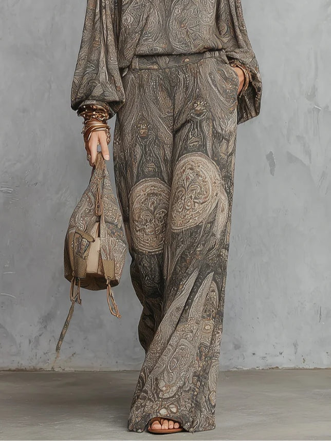Completo composto da top a maniche a lanterna e pantaloni a gamba larga con fantasia paisley grigia.